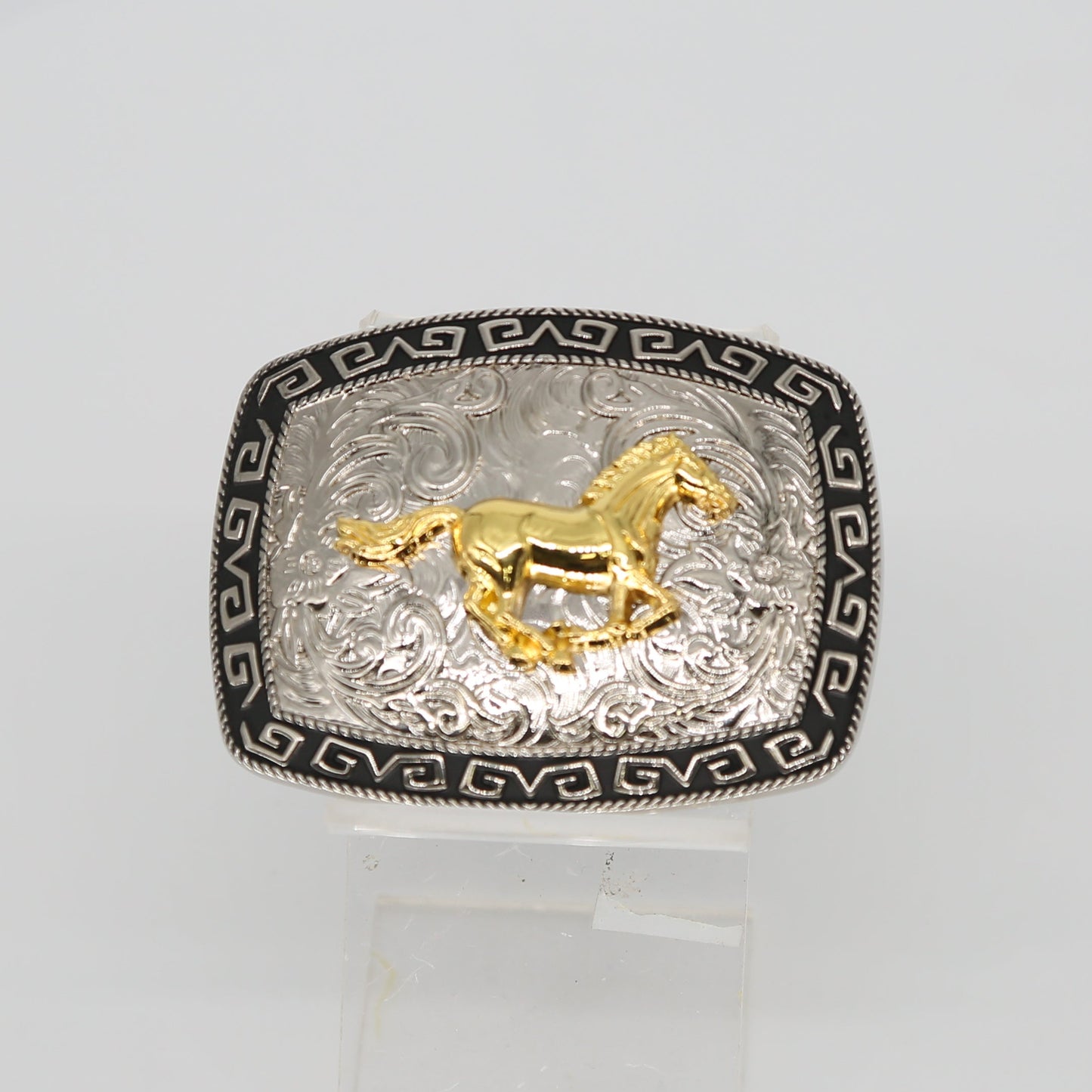Silver ring with gold horse design on a white background